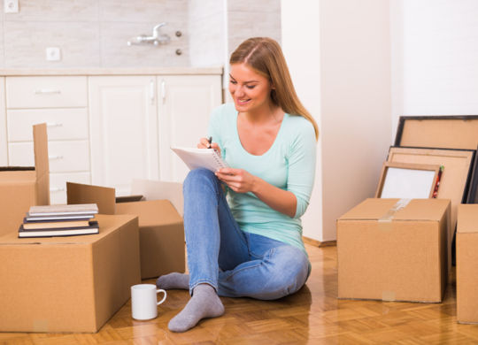 Woman writing in notebook in new home