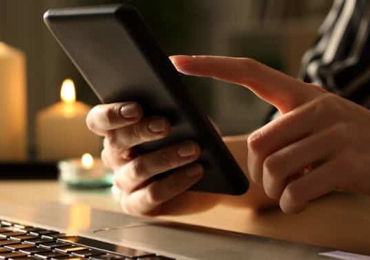 girl-hands-using-phone-on-power-outage-with-candles