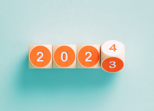 2023 and 2024 written orange cubes on teal background. Horizontal composition with copy space.